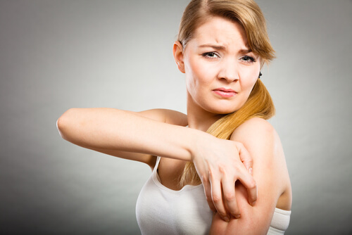 Abbildung einer Frau, die am ihrem Arm kratzt